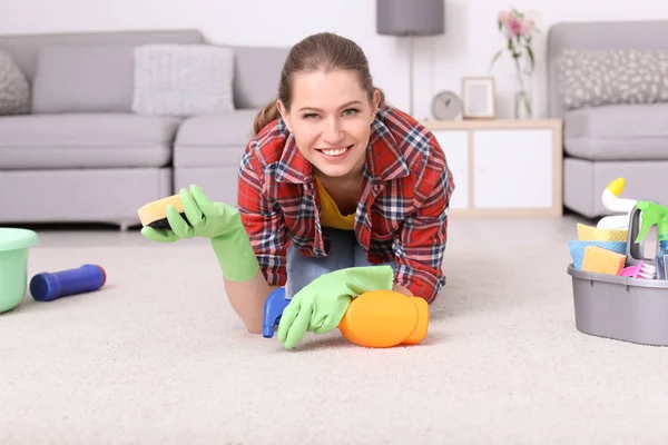 Vrouw schoonmaak tapijt in de woonkamer — Stockfoto