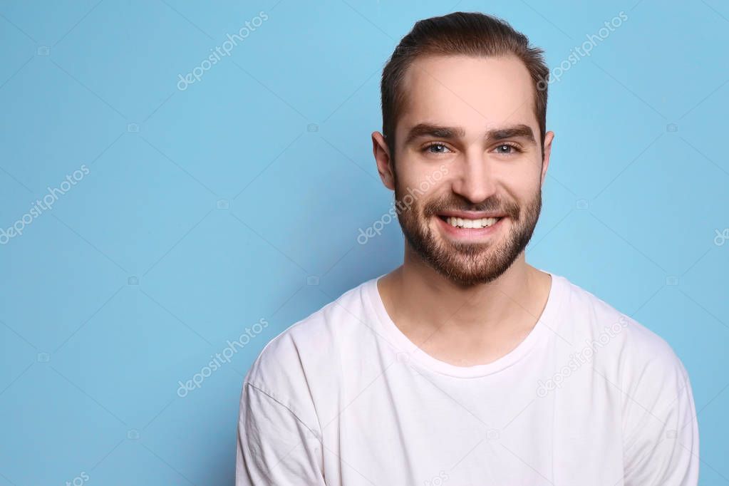 Young man with beautiful smile on grey background. Teeth whitening