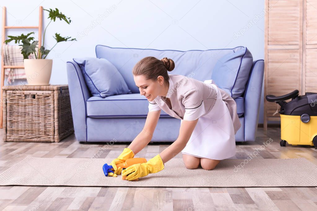Woman cleaning carpet in living room