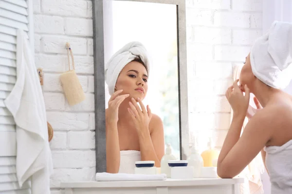 Bella giovane donna con problemi di acne guardando nello specchio a casa — Foto Stock