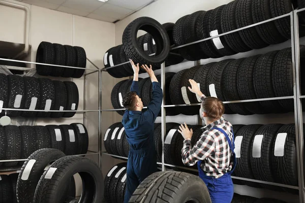 Mladých mužů mechanika s auto pneumatiky v automobilovém servisní středisko — Stock fotografie