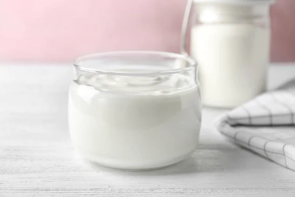 Botol kaca lezat dengan yogurt di atas meja kayu — Stok Foto