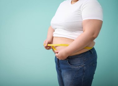 Teyp renk arka plan üzerinde ölçüm ile kilolu kadın