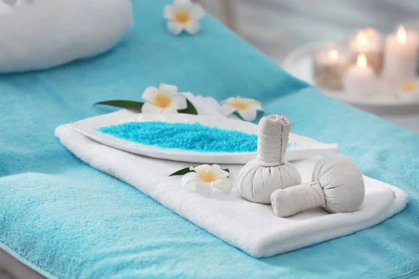 Fleurs, boules à base de plantes et sel de mer sur table de massage dans le salon de spa — Photo