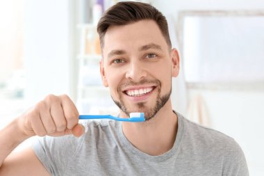 Genç adam kapalı Dişlerini fırçalıyor