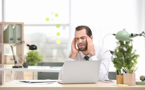 Giovane uomo che soffre di mal di testa in ufficio — Foto Stock