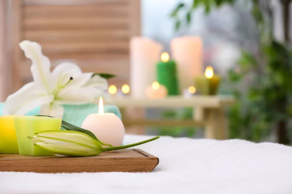Schöne Komposition mit Blumen und Kerzen auf Massagetisch im Salon — Stockfoto