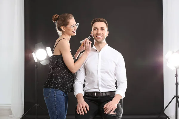 Artista de maquiagem profissional trabalhando com jovem no estúdio de fotos — Fotografia de Stock