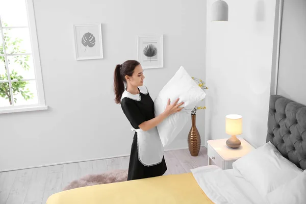 Młoda pokojówka Dokonywanie łóżko w pokoju hotelowym — Zdjęcie stockowe