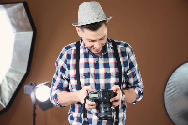 Fotógrafo profissional com câmera e equipamentos de iluminação em estúdio — Fotografia de Stock