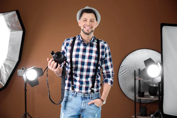 Fotógrafo profesional con cámara y equipo de iluminación en estudio — Foto de Stock