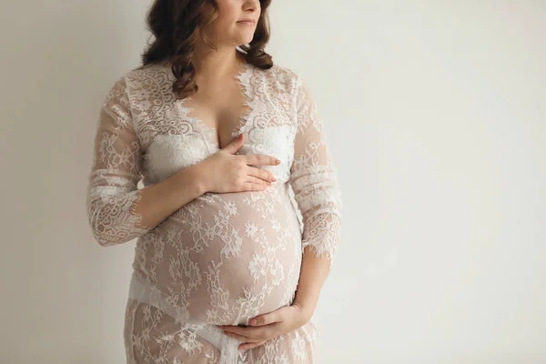 Młoda kobieta w ciąży w elegancki strój na jasnym tle — Zdjęcie stockowe