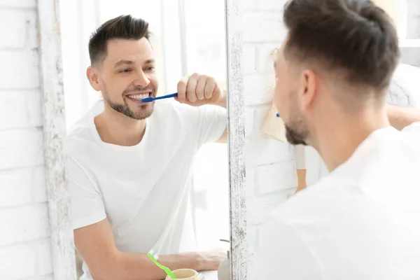 Junger Mann putzt sich im Badezimmer die Zähne — Stockfoto