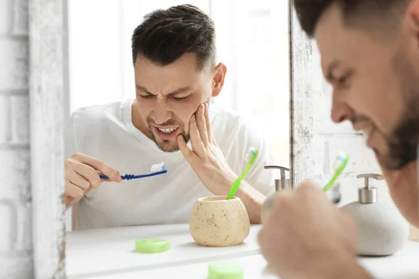 Junger Mann leidet unter Zahnschmerzen im Badezimmer — Stockfoto