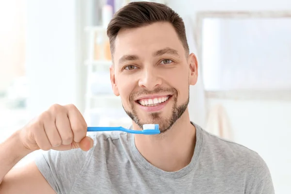 Молодой человек чистит зубы внутри — стоковое фото