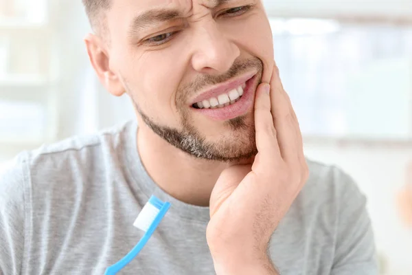 Jeune homme souffrant de maux de dents à l'intérieur — Photo