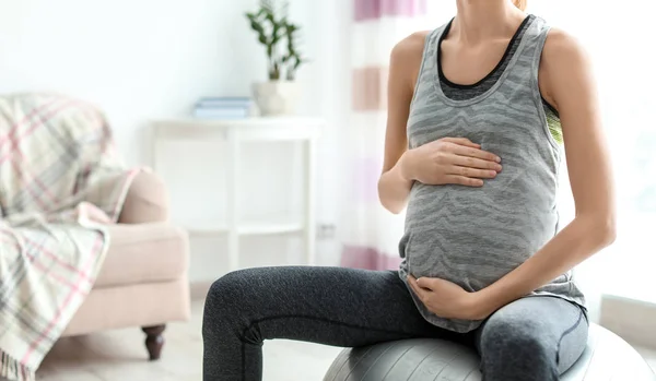 Jeune femme enceinte faisant des exercices à la maison — Photo