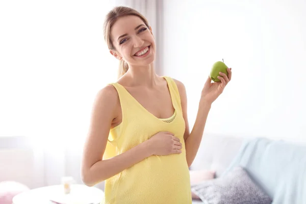 젊은 임신 부 집에서 사과 들고 — 스톡 사진