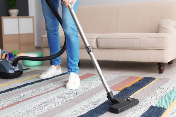 Mann staubt Teppich zu Hause mit Staubsauger ab — Stockfoto