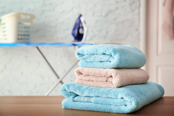 Pilha de toalhas limpas na mesa dentro de casa — Fotografia de Stock
