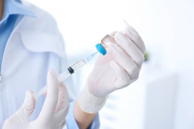 Şişe ve hastanede şırınga ile kadın doktor. Aşı günü