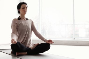 Spor kadını evde yoga yapıyor.