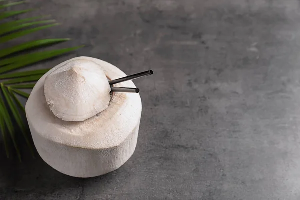 Свіжий кокосовий напій в горіху на сірому фоні — стокове фото