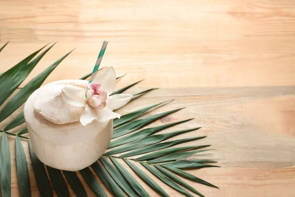 Композиція зі свіжим кокосовим напоєм в горіху на дерев'яному фоні — стокове фото