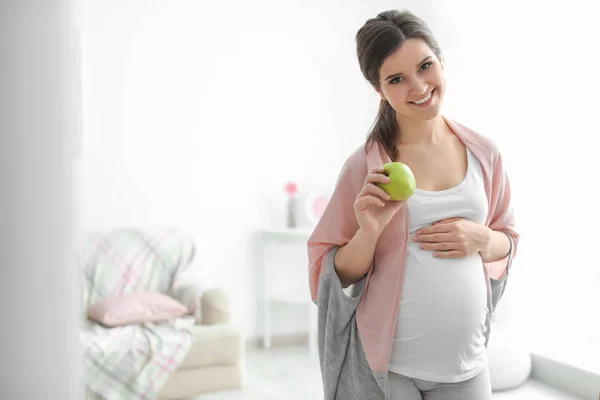 Young pregnant woman holding apple at home — Stock Photo, Image