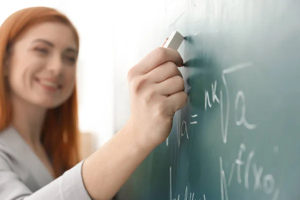 Guru muda yang cantik menulis di papan tulis di kelas — Stok Foto