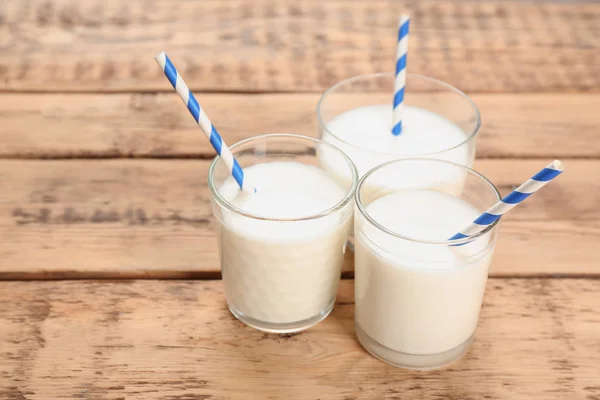 Vasos de leche sobre mesa de madera. Productos lácteos frescos —  Fotos de Stock