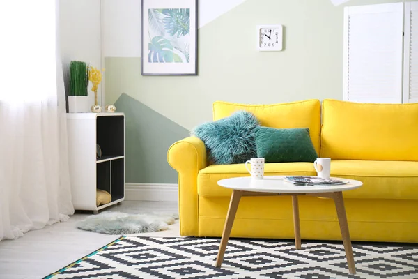 Стильный интерьер гостиной с удобным диваном и столом — стоковое фото