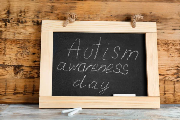 Schoolbord met zin "Autisme awareness day" op tafel — Stockfoto