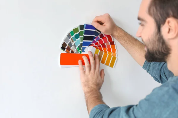 Young man with color palette on white background — Stock Photo, Image