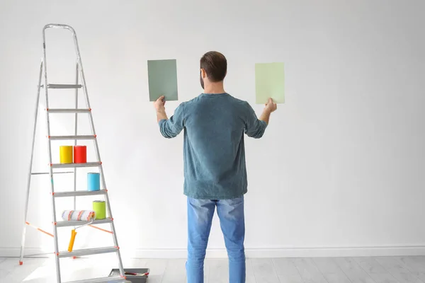 Νεαρός άνδρας επιλέγοντας χρώμα για εσωτερικούς χώρους τοίχο — Φωτογραφία Αρχείου
