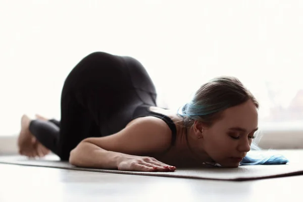 Femeie tânără care practică yoga în interior — Fotografie, imagine de stoc