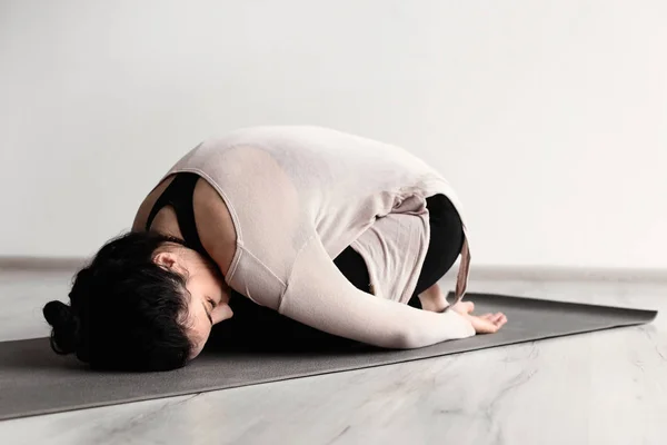 Mujer deportiva practicando yoga en interiores — Foto de Stock