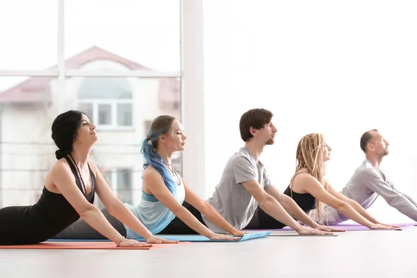 Grupo de personas que practican yoga en interiores — Foto de Stock