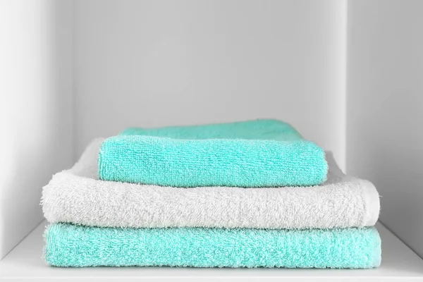 Stack of clean towels on shelf — Stock Photo, Image