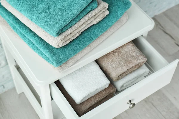 Mesa pequena com toalhas limpas no banheiro — Fotografia de Stock