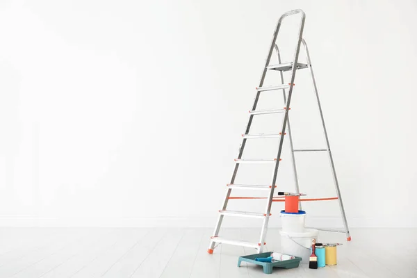 Step ladder and decorator's tools in light room — Stock Photo, Image