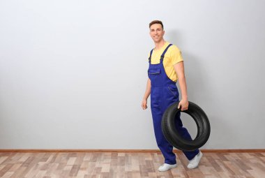 Işık duvar arka plan üzerinde otomobil lastiği ile erkek makinist
