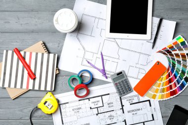 Dekoratör'ın araçlarına ve proje çizimleri, düz ahşap arka plan üzerinde yatıyordu