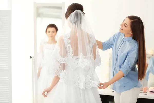 Estilista de moda preparando noiva antes de seu casamento no quarto — Fotografia de Stock