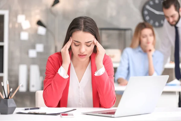 Jonge vrouw met hoofdpijn op kantoor — Stockfoto