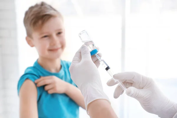 Läkare fylla sprutan med medicin och barn på bakgrunden. Vaccination dag — Stockfoto