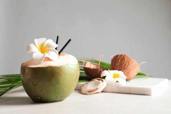 Mooie compositie met verse groene kokosnoot op tafel tegen de grijze achtergrond — Stockfoto