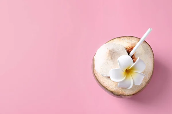 Färska gröna kokos med dricksvatten halm och blomma på färg bakgrunden, ovanifrån — Stockfoto