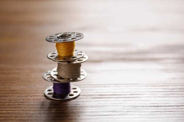 Spools with threads for tailoring on wooden background — Stock Photo, Image