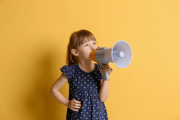 Милая маленькая девочка с мегафоном на цветном фоне — стоковое фото